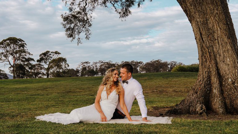 Wedding couple beside a tree at the venue